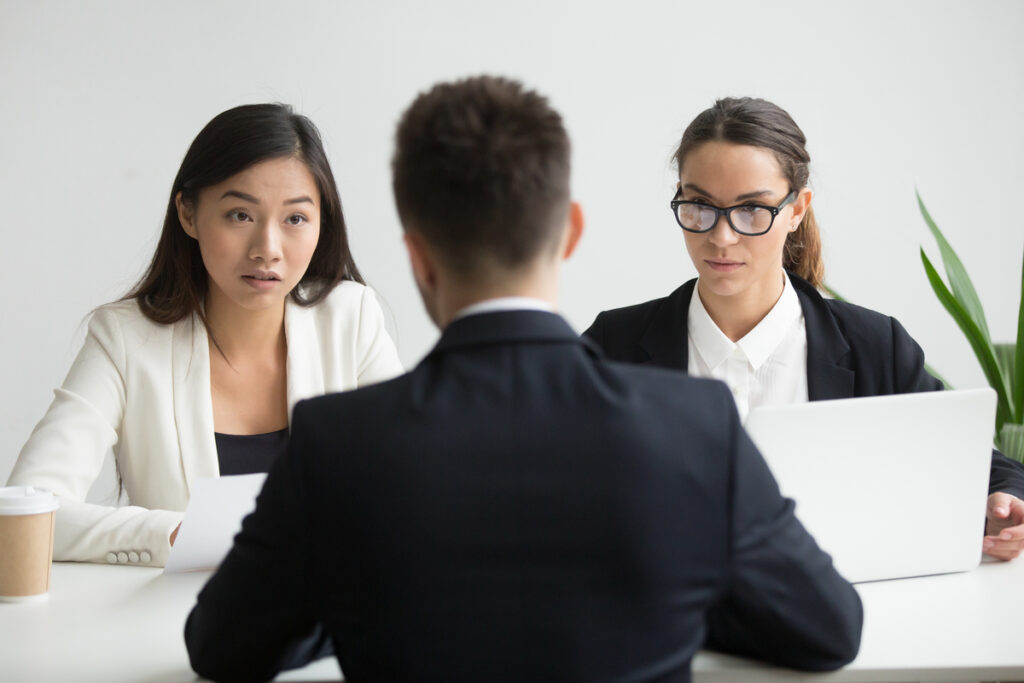 serious unconvinced diverse hr managers interviewing male job applicant 1024x683